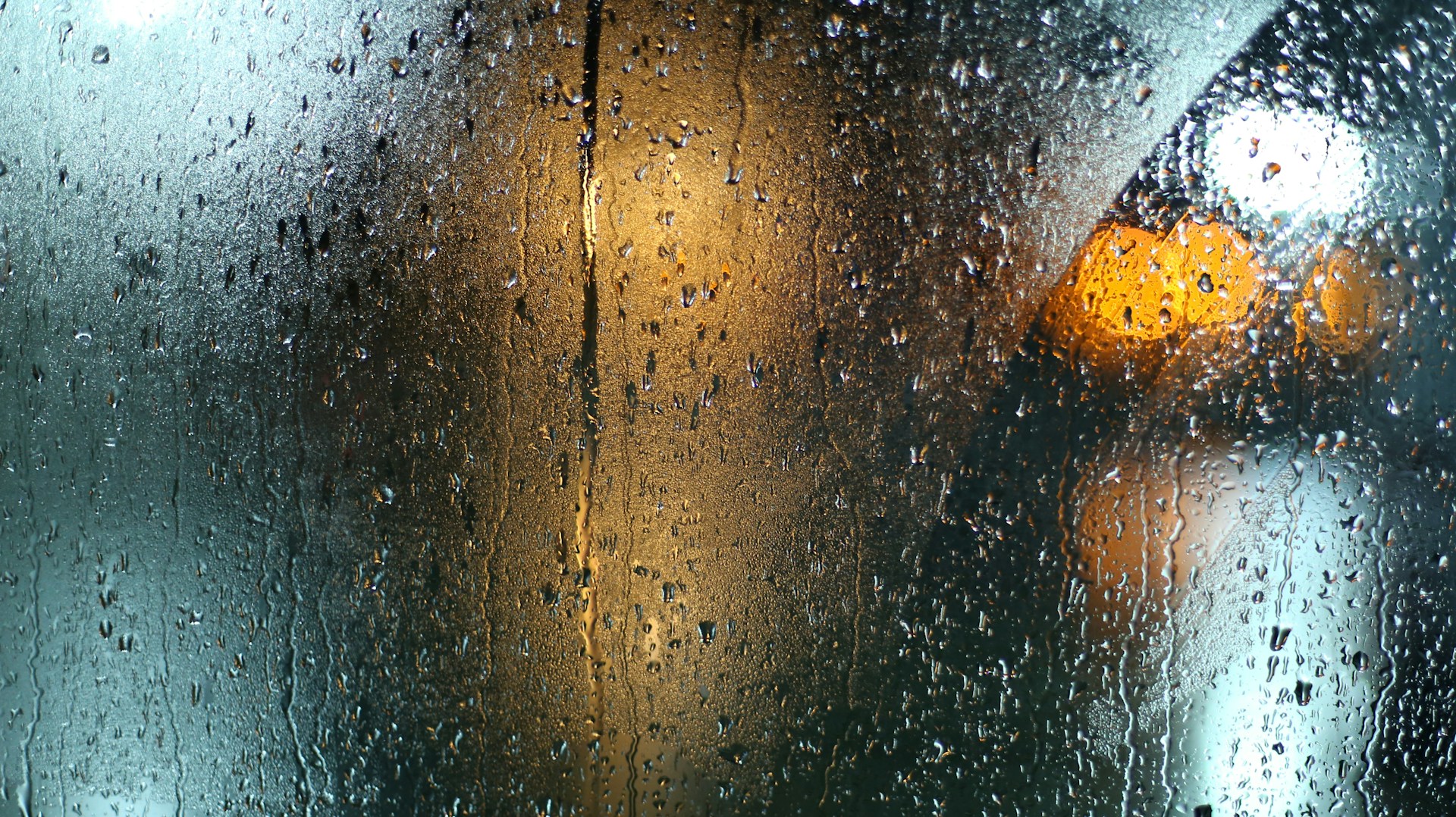 雨水覆盖的玻璃后方是模糊的暖色灯光,信号被噪声遮蔽